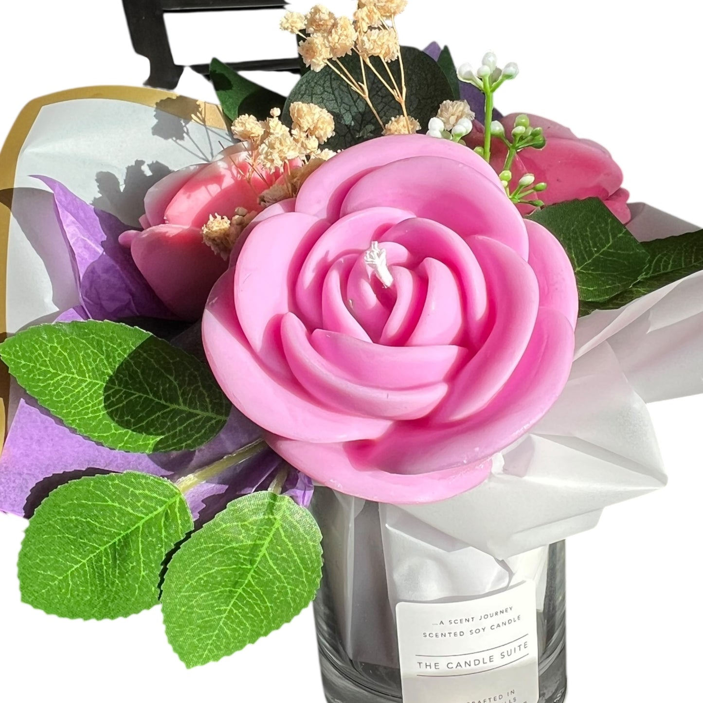 Bouquet of pink roses and green leaves with a candle labeled 'The Candle Suie' on a white background.