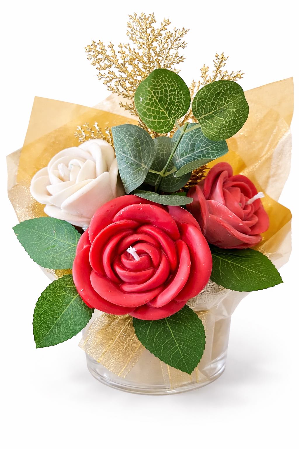 Bouquet of red and white flowers with green leaves in a clear container on a white background