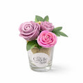 Decorative candle with pink and purple flowers and green leaves on a white background, branded 'The Candle Suite'.