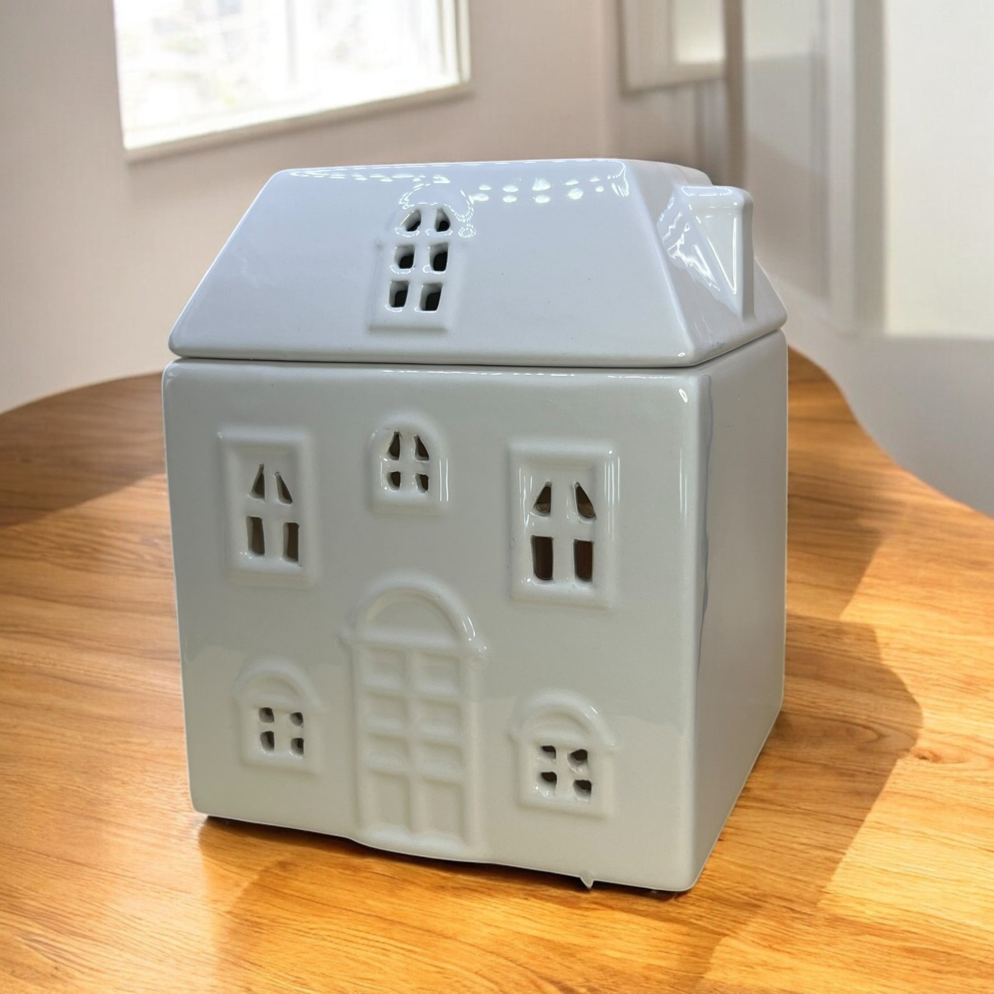 Charming ceramic cottage-shaped wax melt burner, perfect for adding cozy ambiance to any room. Perfect with our wax melts