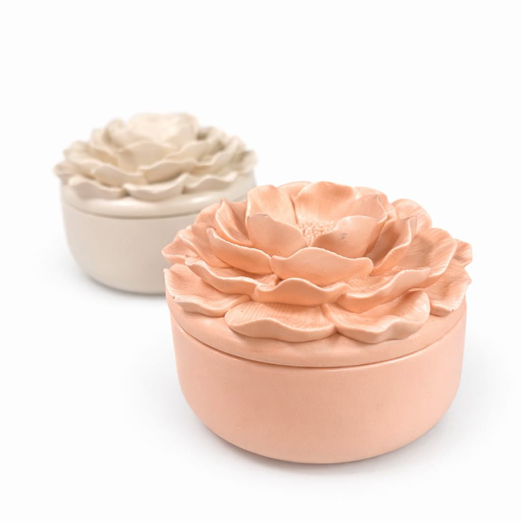 Two ceramic flower pots, one beige and one peach, on a white background