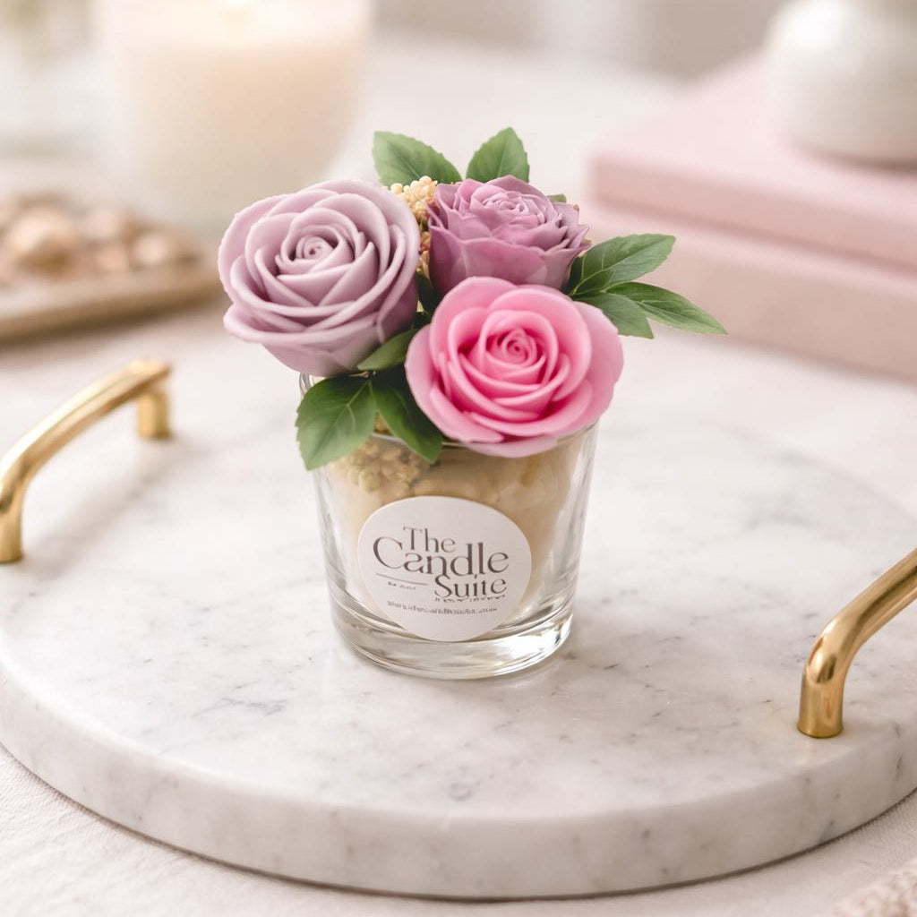 Decorative candle with pink and purple flowers on a marble tray.