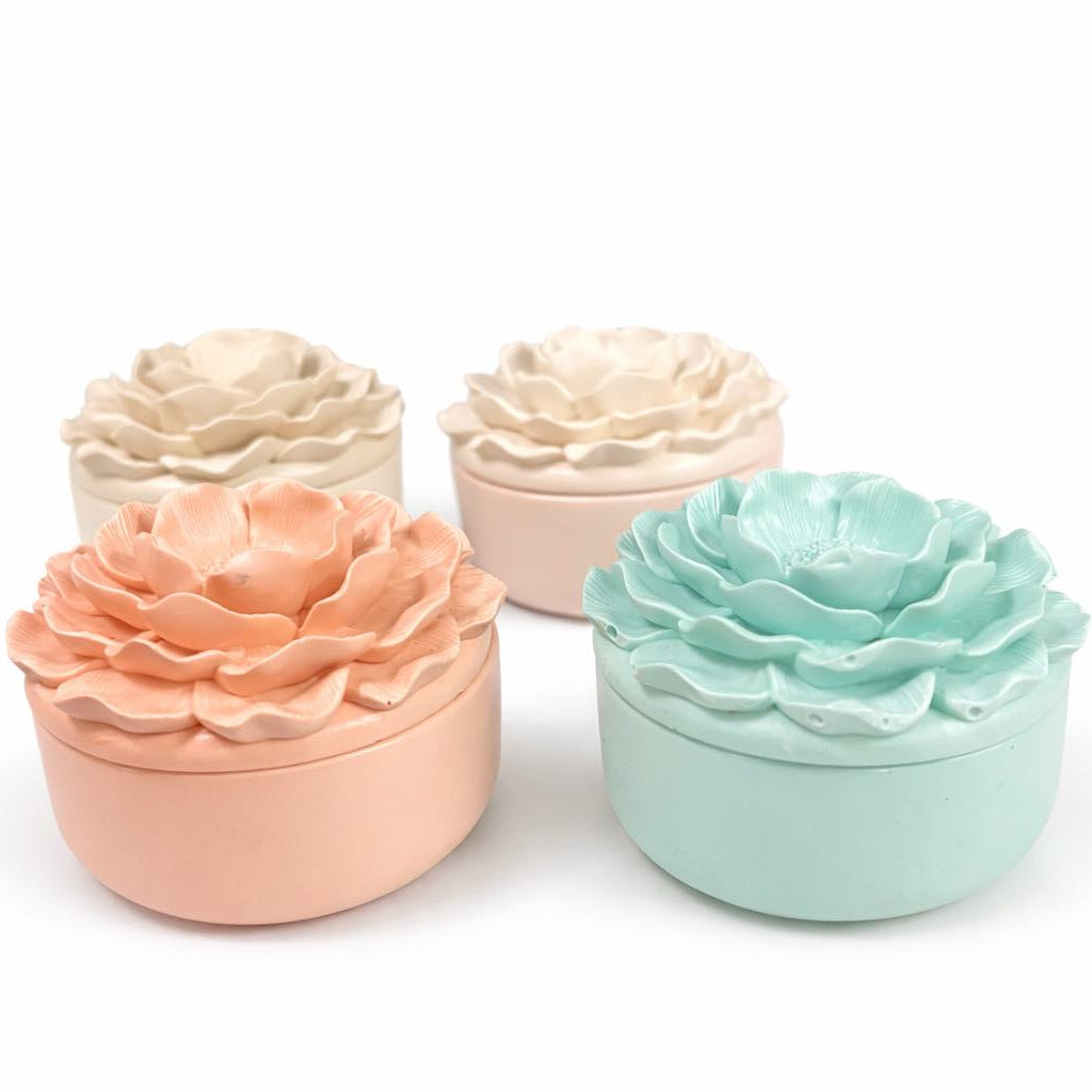 Four pastel-colored flower-shaped containers on a white background