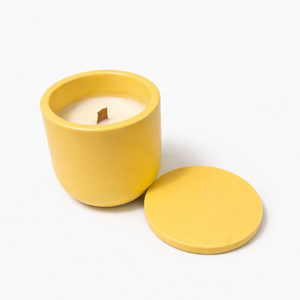 Yellow candle with lid on a white background