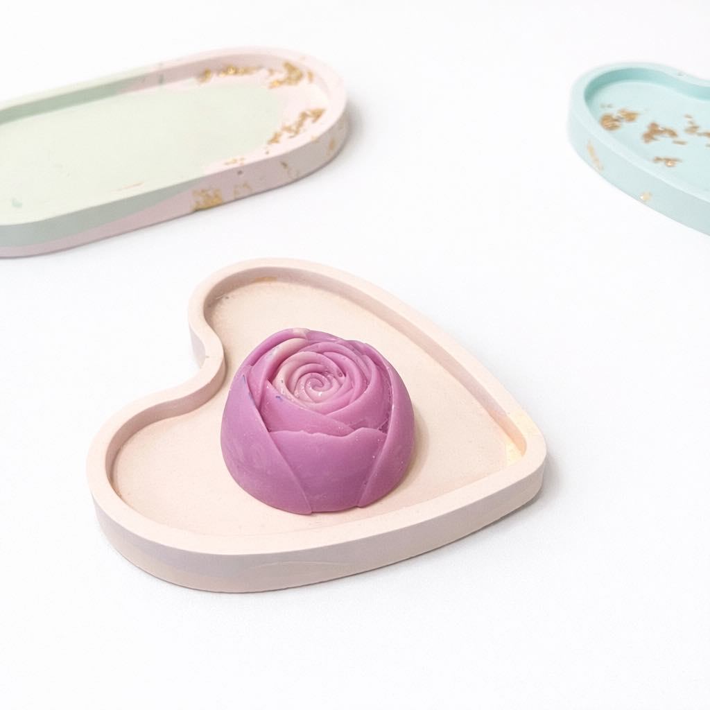 Heart-shaped pink rose-shaped object on a pastel pink trinket