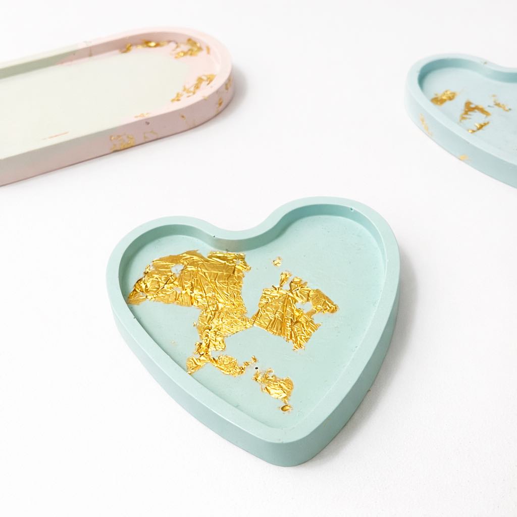 Heart-shaped tray with gold design on a green background