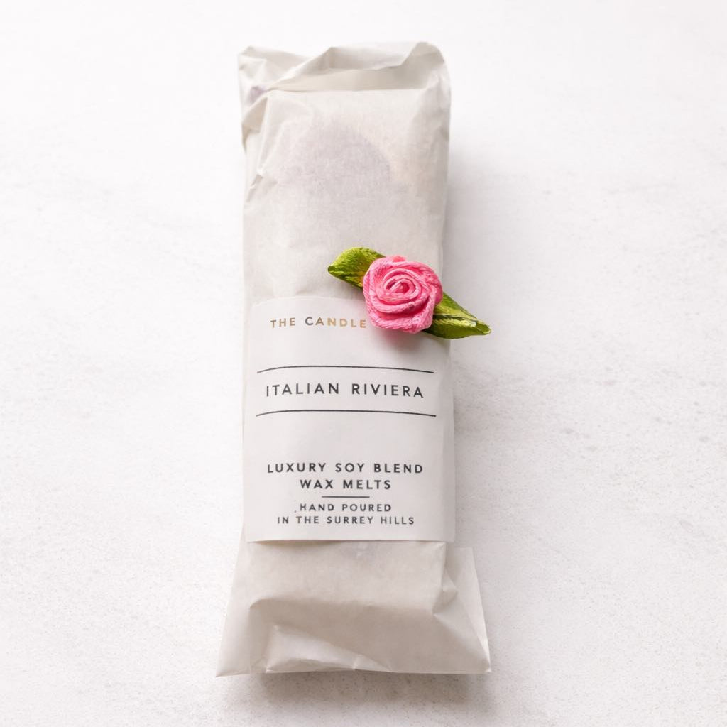 Pack of Italian Riviera luxury soy blend wax melts with a pink rose on a white background