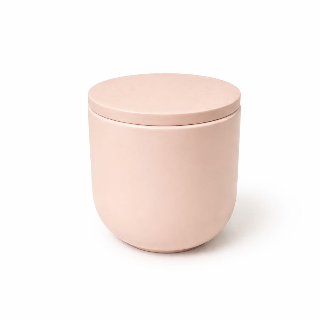 Pink ceramic jar with lid on a white background