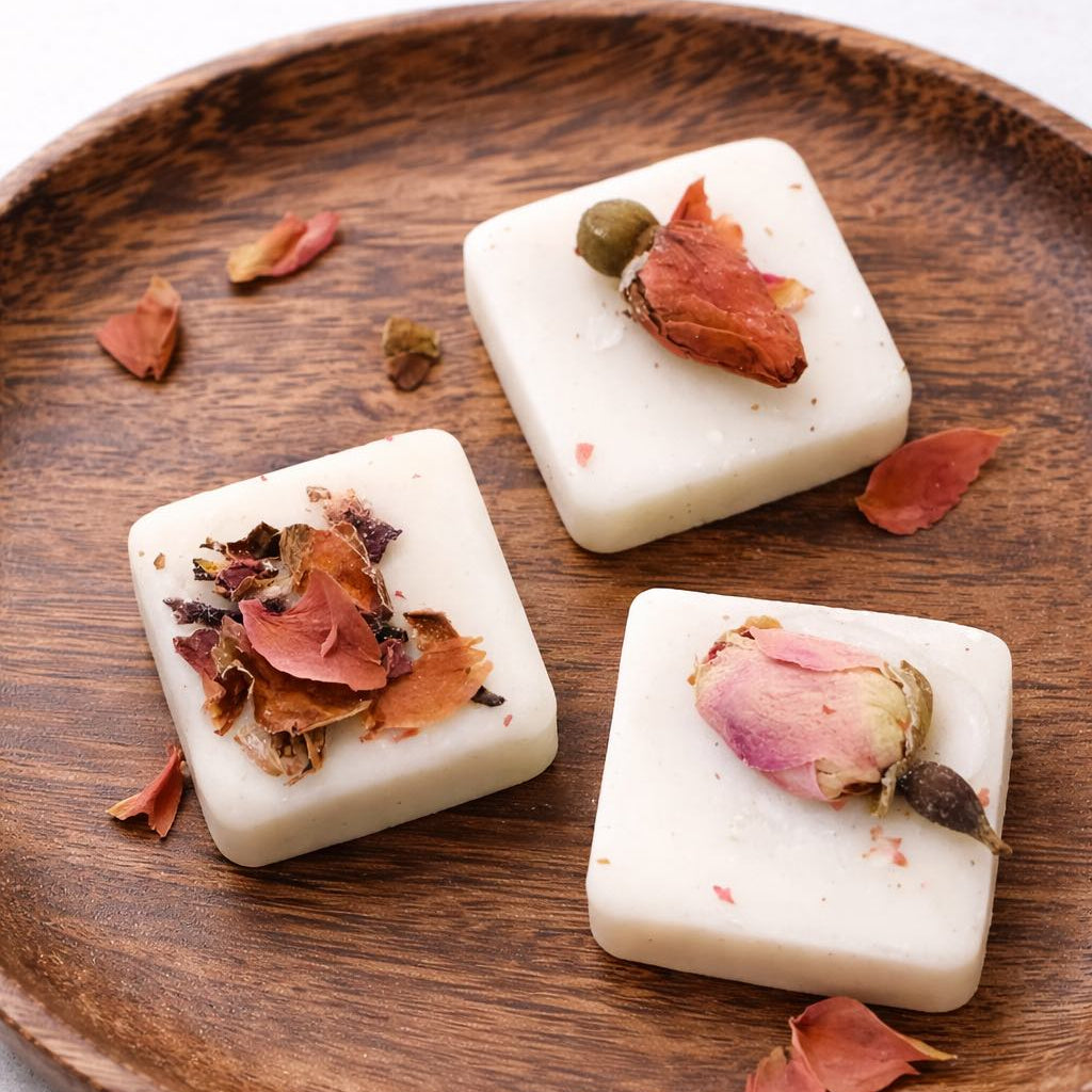 Three wax melt square with dried flowers on a wooden plate