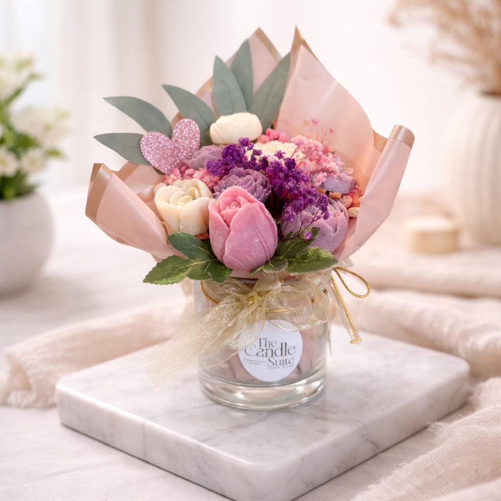 Small bouquet of flowers in a glass jar on a marble slab with a soft blurred background