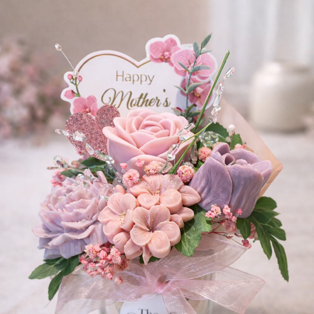 Mother’s Day floral candle bouquet with pink roses, lavender wax flowers, and decorative pink accents