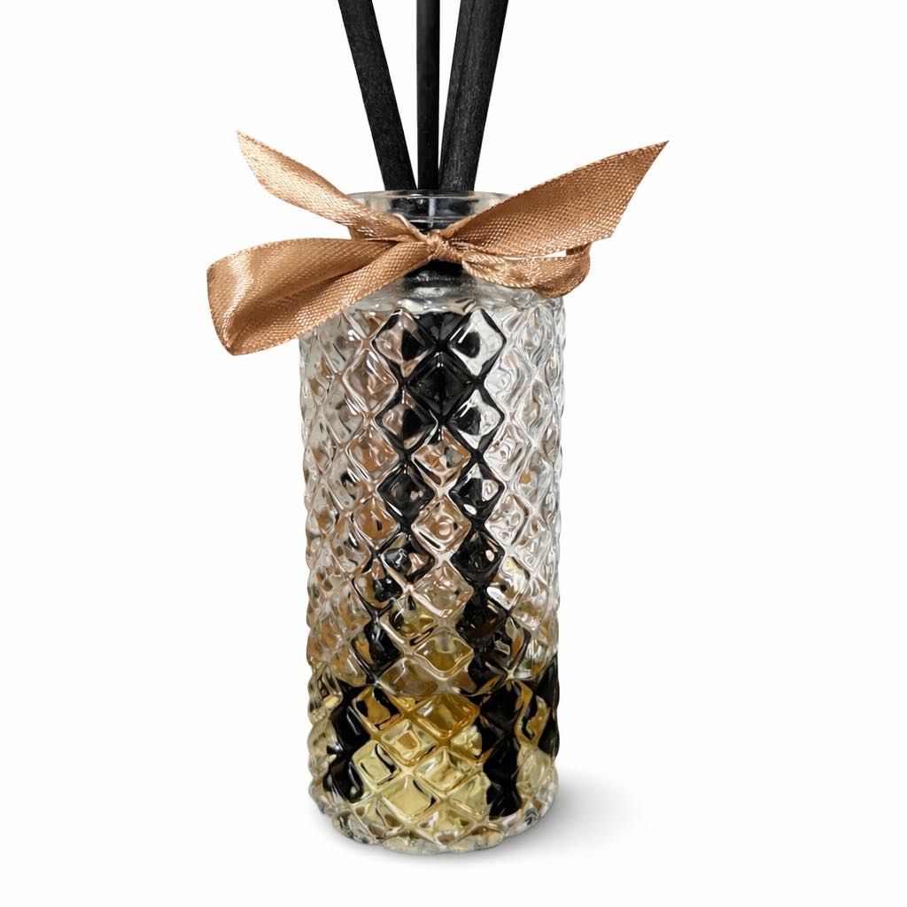 Decorative diffuser bottle with wicker lid and black sticks on a white background