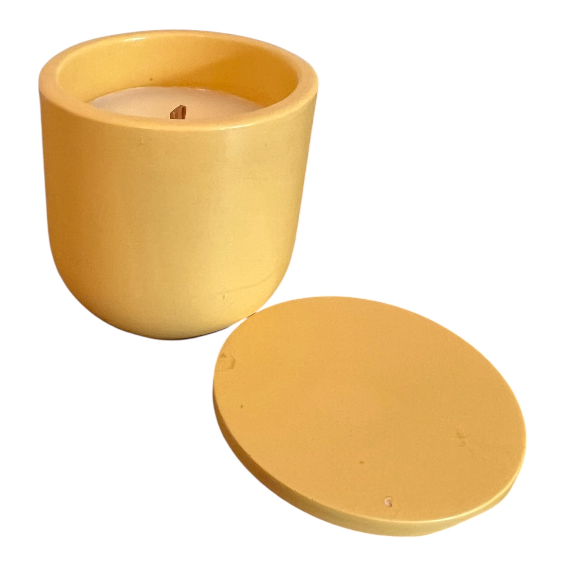 Yellow candle in a pot with lid on a white background