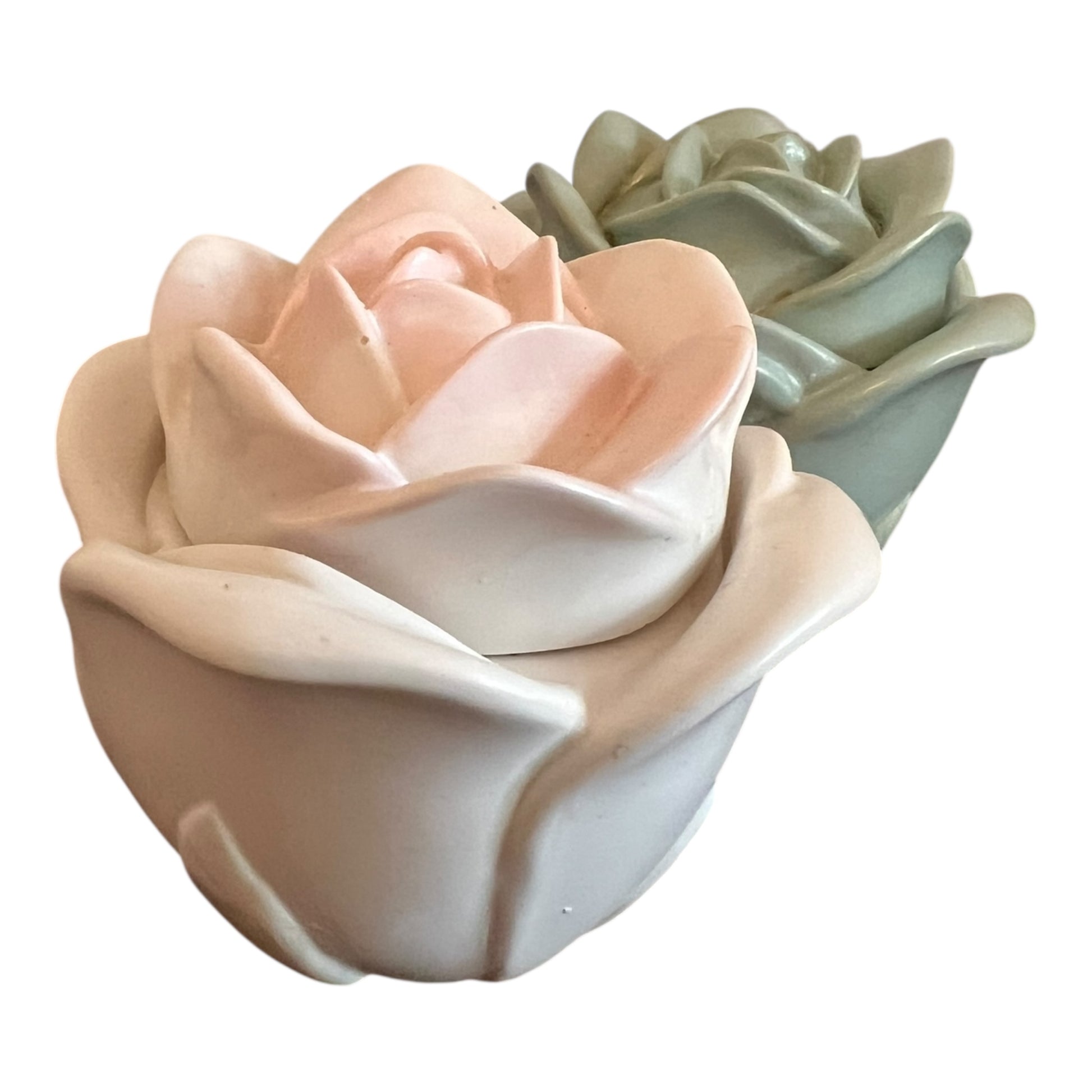 Two ceramic flower pots, one pink and one green, on a white background