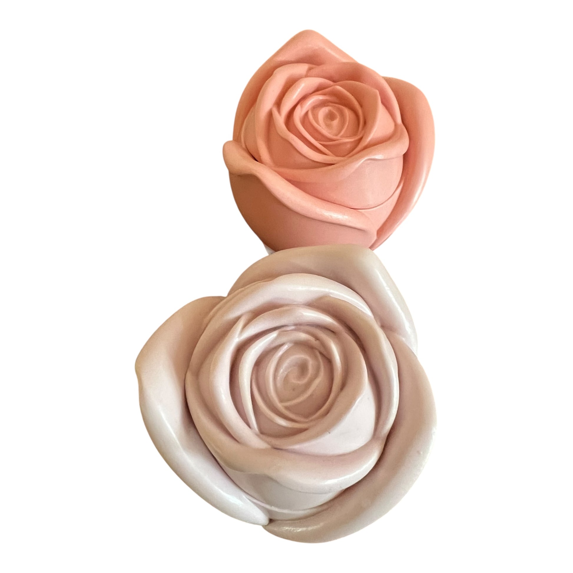 Two pink rose-shaped soaps on a white background