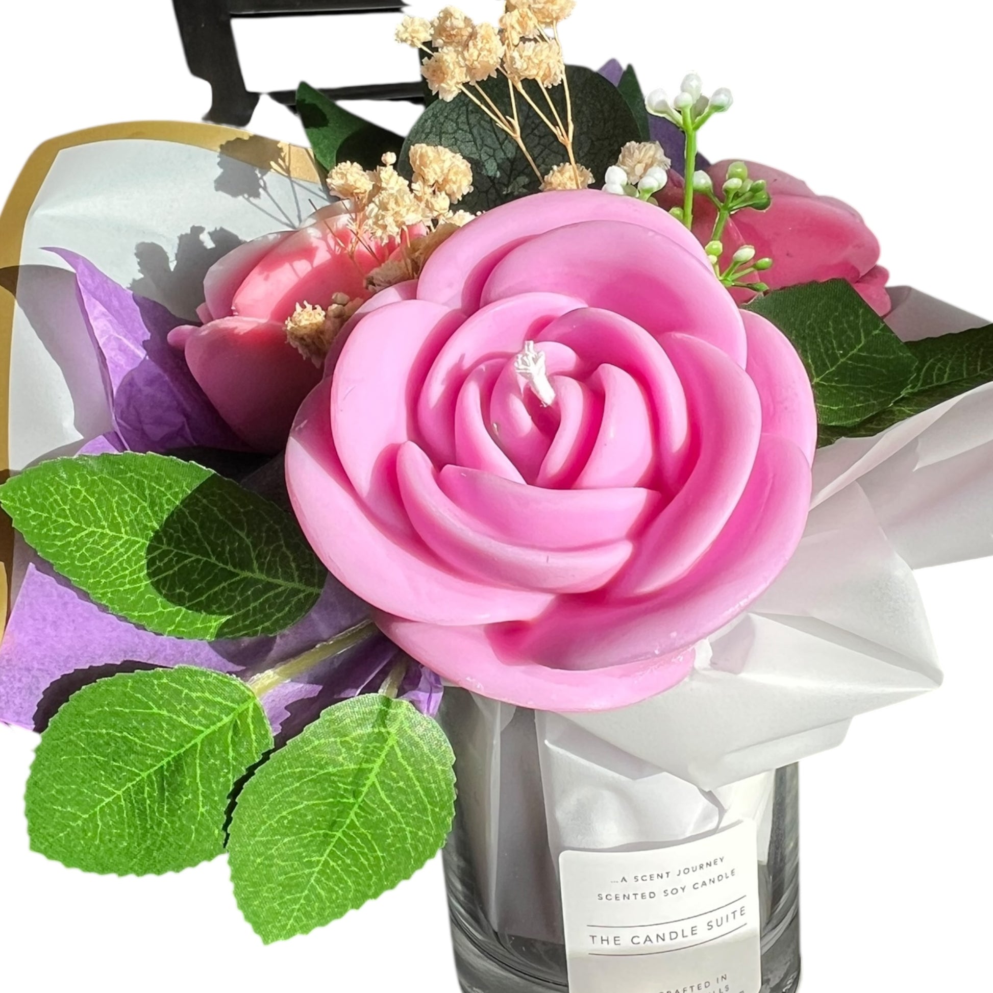 Bouquet of pink roses and green leaves with a candle labeled 'The Candle Suie' on a white background.