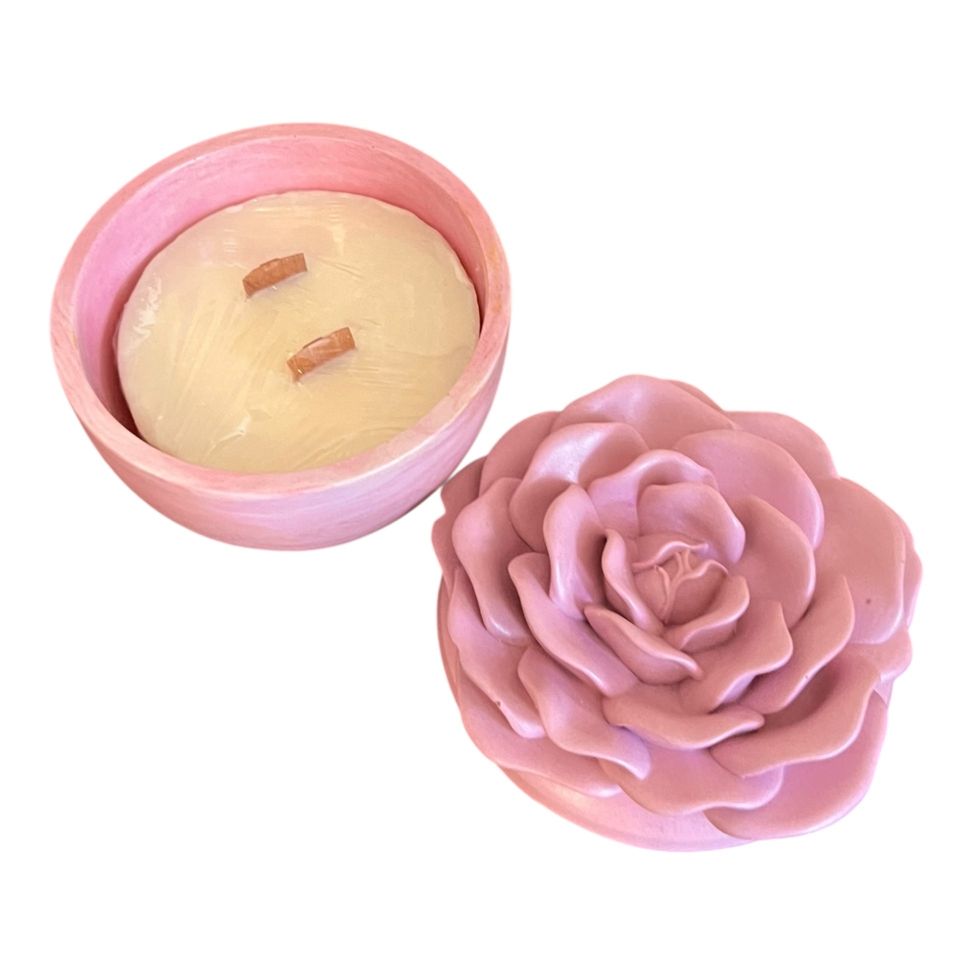 Pink rose-shaped candle mold with a candle inside on a white background
